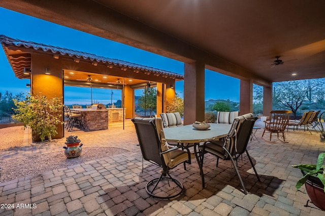 view of patio with ceiling fan, outdoor dry bar, and outdoor dining space