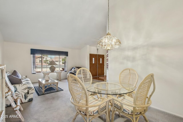 carpeted dining room with a notable chandelier