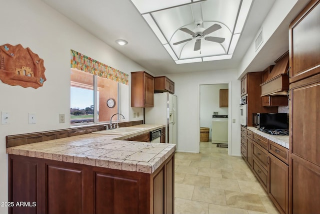 kitchen with premium range hood, washer / clothes dryer, sink, ceiling fan, and white appliances