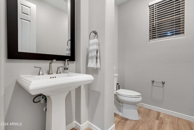 bathroom with toilet and hardwood / wood-style flooring