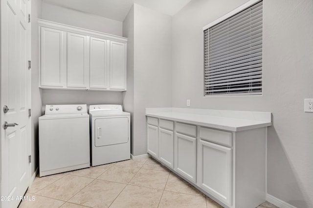 laundry room with cabinets, washer and dryer, and light tile patterned flooring