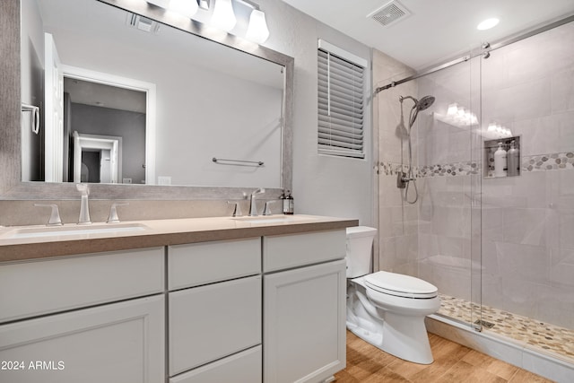 bathroom featuring vanity, toilet, hardwood / wood-style flooring, and a shower with shower door