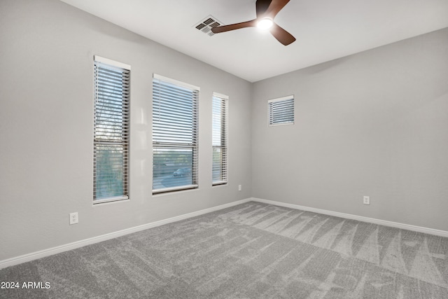 carpeted spare room featuring ceiling fan