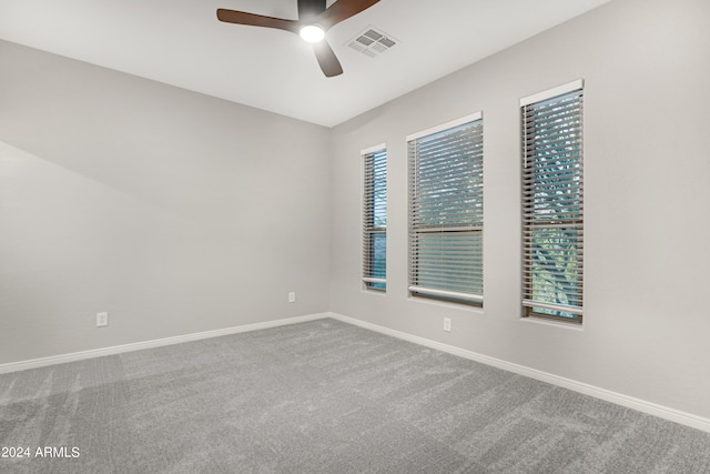 carpeted spare room with ceiling fan and plenty of natural light