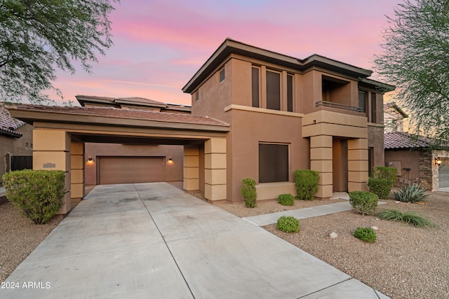 view of front of house featuring a garage, solar panels, and a balcony