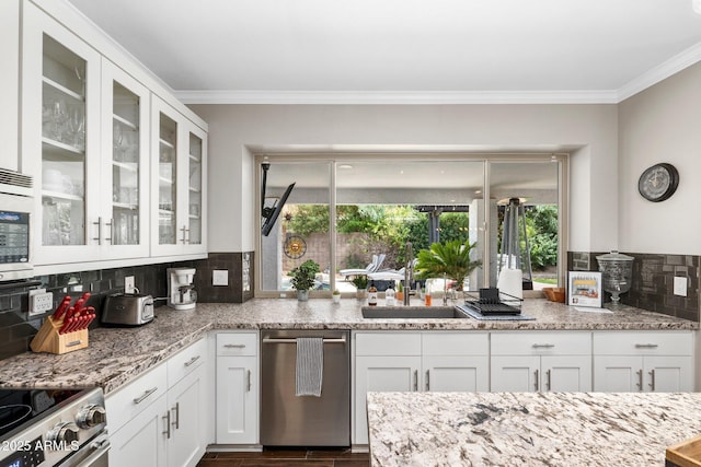 kitchen featuring decorative backsplash, sink, white cabinetry, and appliances with stainless steel finishes