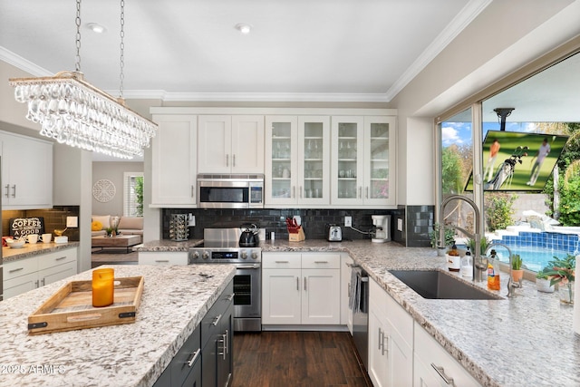 kitchen featuring decorative backsplash, sink, white cabinetry, and appliances with stainless steel finishes