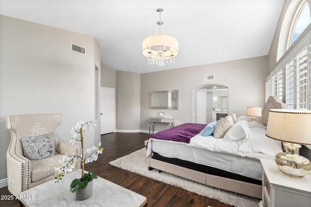 bedroom featuring vaulted ceiling, dark hardwood / wood-style flooring, and a chandelier