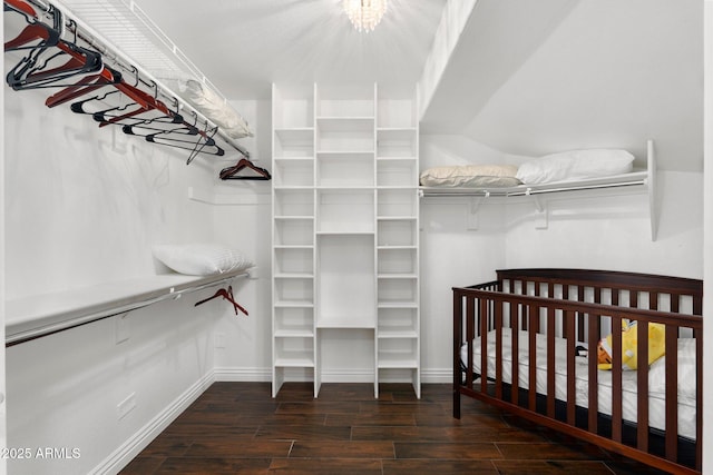 walk in closet with dark hardwood / wood-style floors