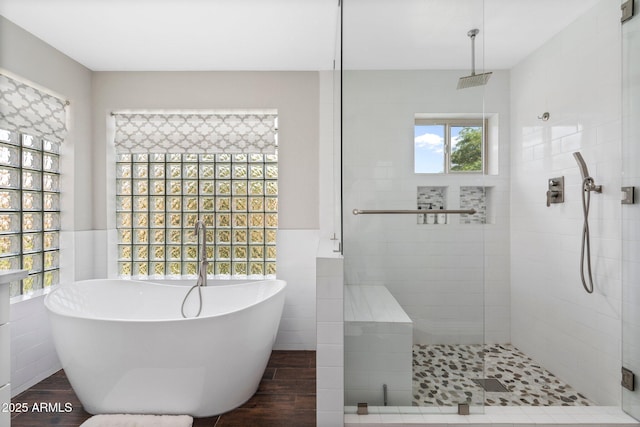 bathroom featuring tile walls, hardwood / wood-style floors, and independent shower and bath