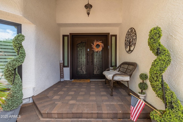 view of exterior entry featuring covered porch