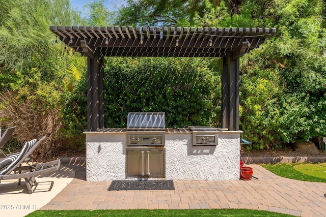 view of patio with exterior kitchen, grilling area, and a pergola