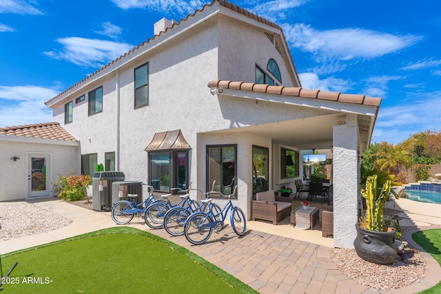 rear view of property with an outdoor hangout area and a patio area