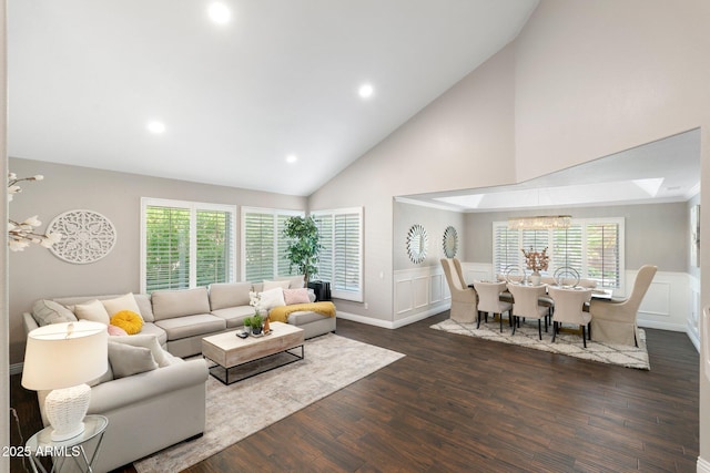 living room with dark wood-type flooring, lofted ceiling, and a chandelier