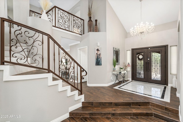 entrance foyer featuring a high ceiling, french doors, and a notable chandelier