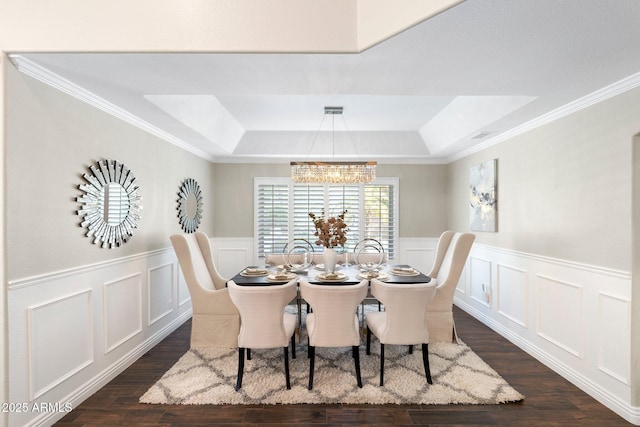 dining area with dark hardwood / wood-style flooring, ornamental molding, and a tray ceiling