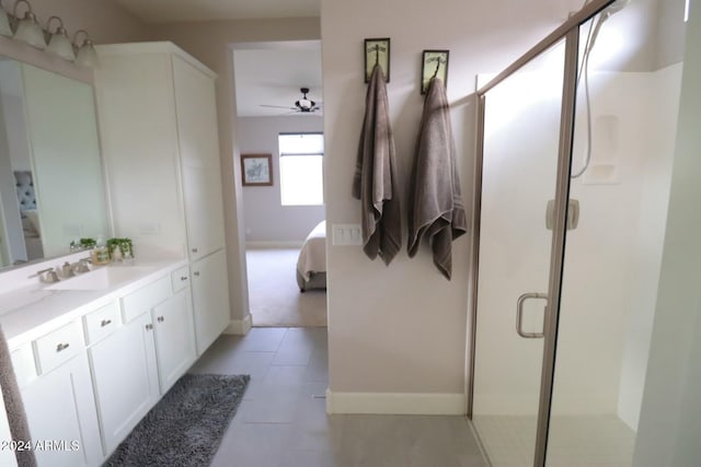 bathroom featuring tile patterned floors, ceiling fan, a shower with door, and vanity