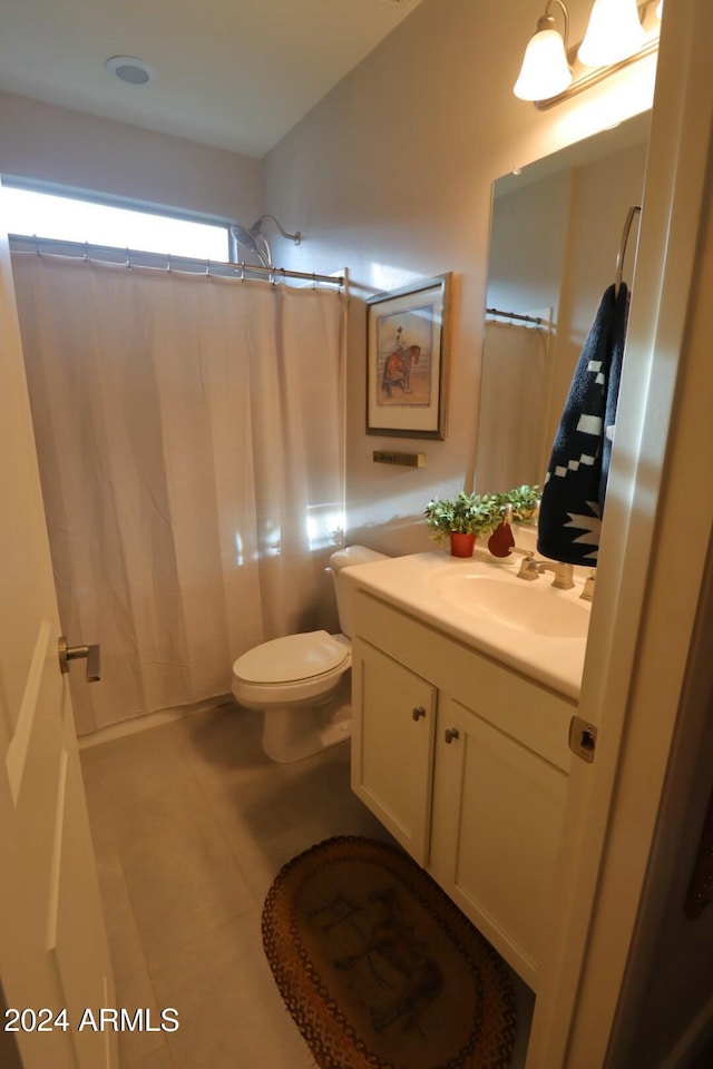 bathroom featuring toilet, vanity, tile patterned floors, and curtained shower