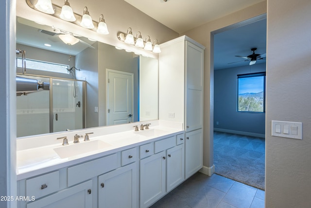 bathroom featuring tile patterned flooring, ceiling fan, a shower with door, and vanity