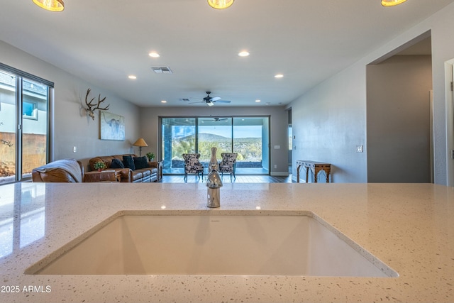 kitchen featuring light stone countertops and ceiling fan