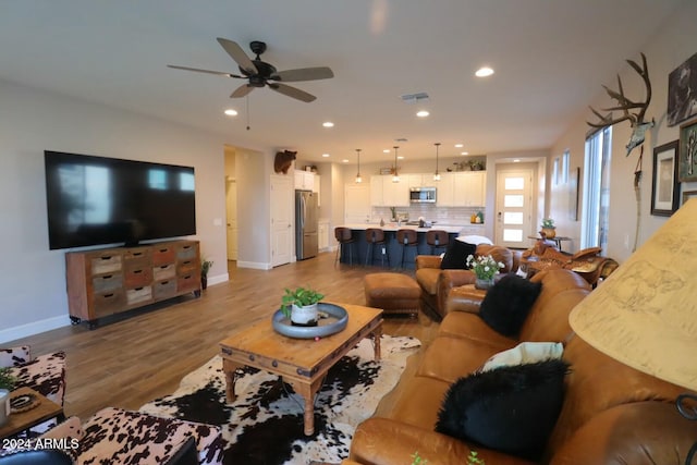 living room featuring ceiling fan and light wood-type flooring