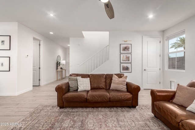 living room featuring ceiling fan and light wood-type flooring