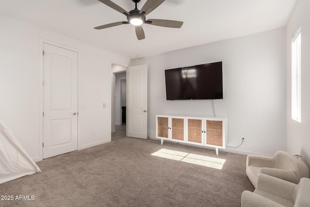 unfurnished living room featuring light carpet and ceiling fan