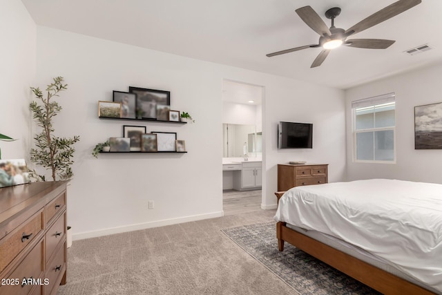 bedroom featuring light carpet, connected bathroom, and ceiling fan