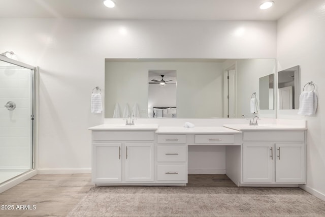 bathroom with vanity, wood-type flooring, a shower with door, and ceiling fan