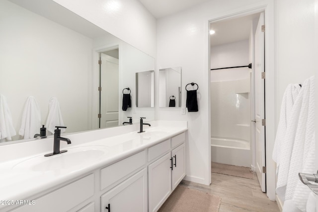 bathroom featuring vanity, hardwood / wood-style floors, and bathing tub / shower combination