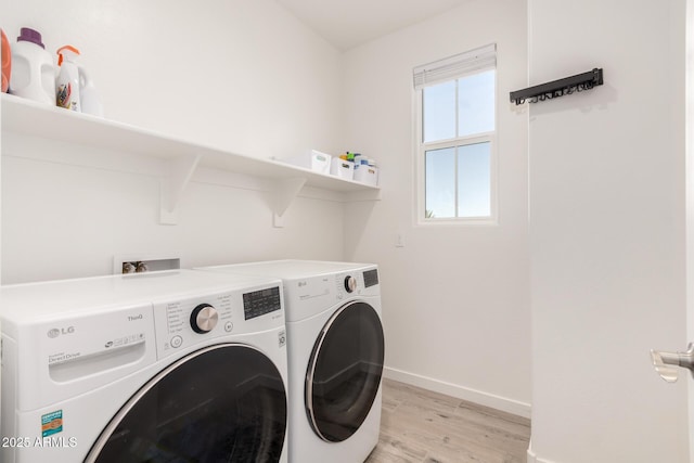 laundry room featuring washer and dryer and light hardwood / wood-style floors