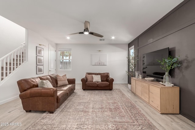 living room featuring ceiling fan and light hardwood / wood-style flooring