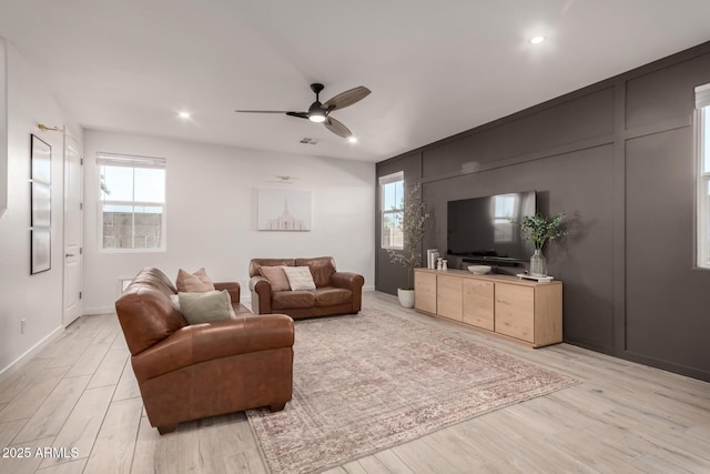 living room with ceiling fan and light hardwood / wood-style flooring