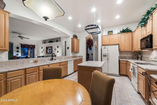 kitchen with tile countertops, white appliances, sink, ceiling fan, and a kitchen island