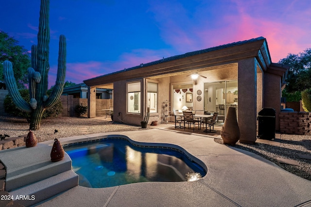 pool at dusk featuring a patio area