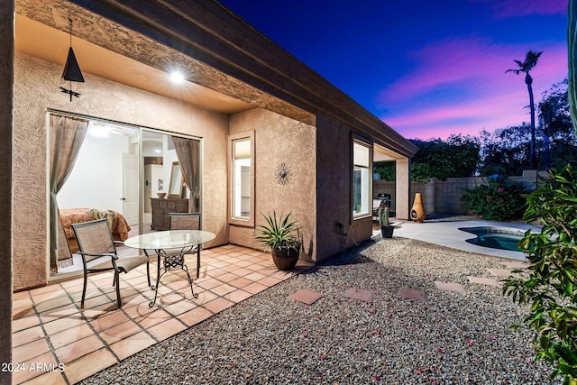 patio terrace at dusk with a fenced in pool