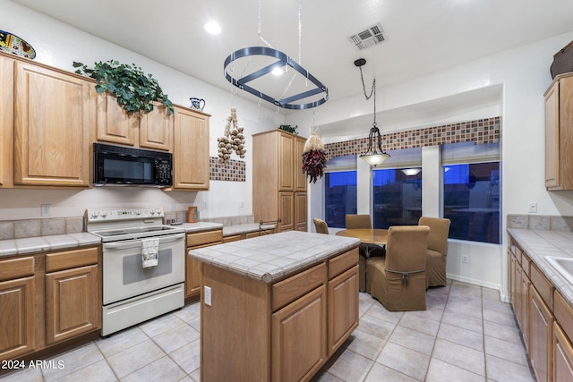 kitchen with tile counters, a center island, hanging light fixtures, white electric range, and light tile patterned flooring