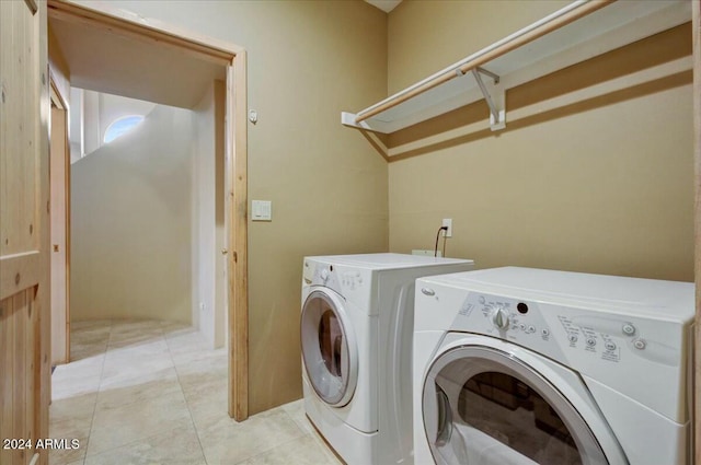 laundry area with washer and dryer and light tile patterned floors