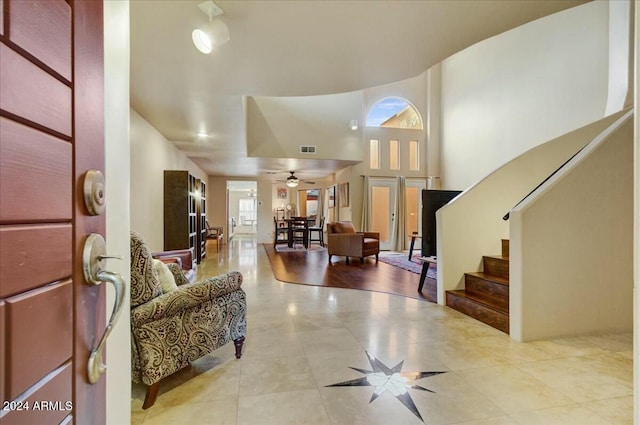 tiled foyer with a high ceiling, french doors, and ceiling fan