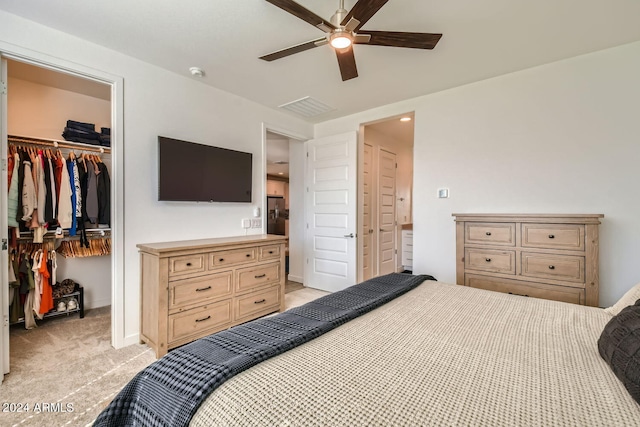 carpeted bedroom featuring a spacious closet, a closet, and ceiling fan