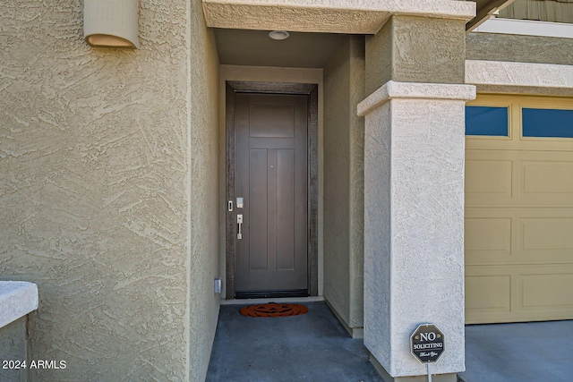 view of exterior entry featuring a garage and elevator