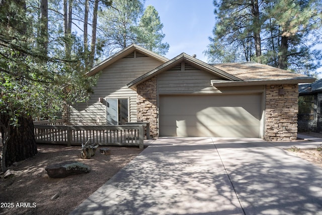 view of front of home featuring a garage, stone siding, a wooden deck, and concrete driveway