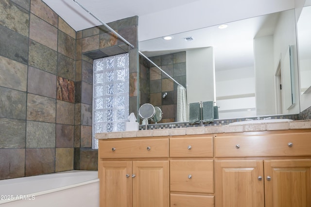 bathroom featuring double vanity, a tub to relax in, a tile shower, and visible vents