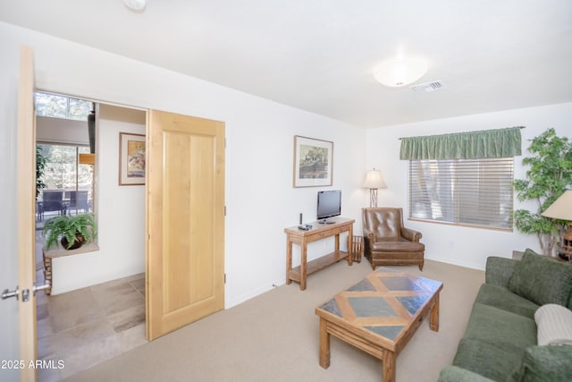 carpeted living area with baseboards and visible vents