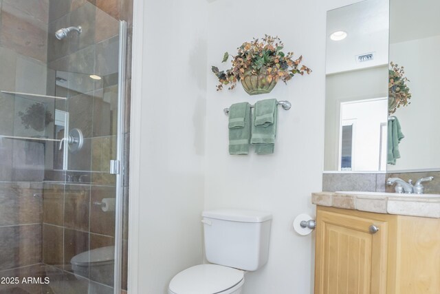 full bathroom with toilet, a stall shower, visible vents, and vanity