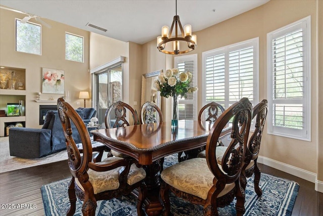 16420 N Thompson Peak Pkwy Unit 1002, Scottsdale, AZ 85260 - dining area with a chandelier, a fireplace, baseboards, and wood finished floors