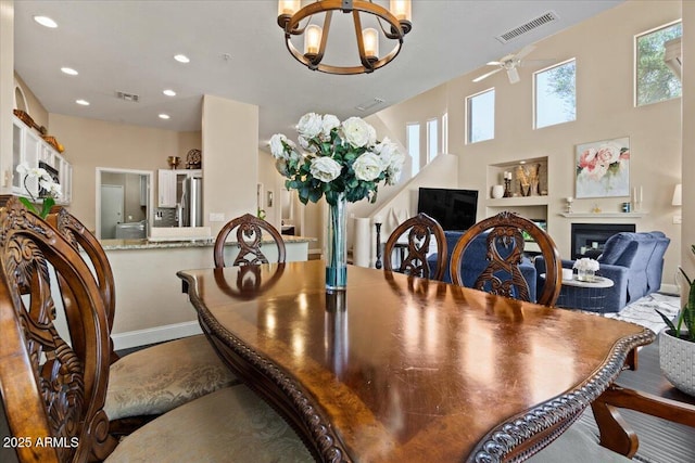 16420 N Thompson Peak Pkwy Unit 1002, Scottsdale, AZ 85260 - dining area featuring a chandelier, a fireplace, baseboards, recessed lighting, and ceiling fan