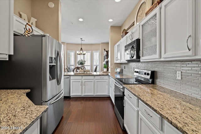 16420 N Thompson Peak Pkwy Unit 1002, Scottsdale, AZ 85260 - kitchen featuring appliances with stainless steel finishes, backsplash, white cabinetry, dark wood-type flooring, and a chandelier