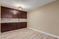 interior space with dark brown cabinets and light wood-type flooring