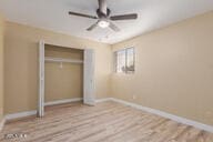 unfurnished bedroom featuring light wood-type flooring, a closet, and ceiling fan